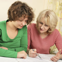 Adult woman and younger woman discussing documents