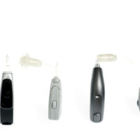 A row of hearing aids in several shapes, sizes and colours