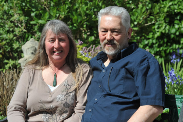 Tony and Sue Long sitting on a bench in a garden