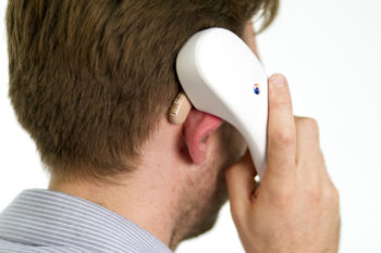 Man with telephone using an inductive coupler (loop) with hearing aids