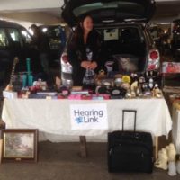 Ramona stands behind a stall at a car boot sale
